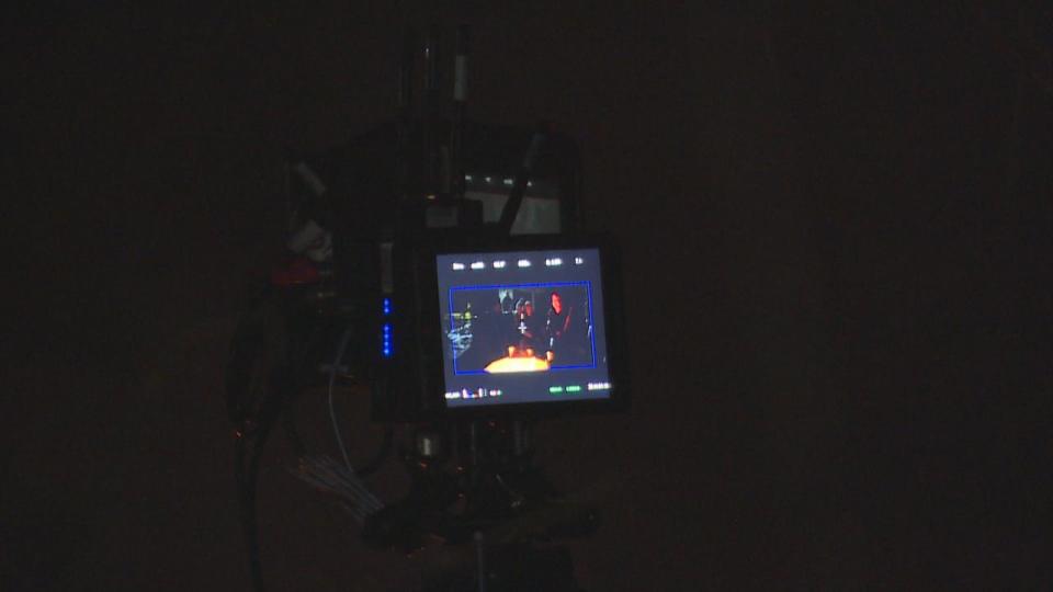 A monitor captures cast members in the midst of acting out a scene. 