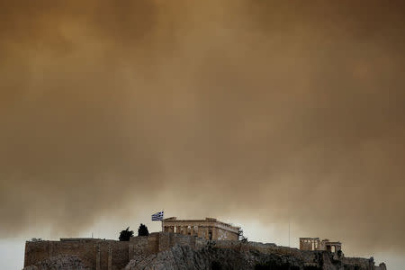 Smoke from a wildfire burning outside Athens is seen over the Parthenon temple atop the Acropolis hill in Athens, Greece, July 23, 2018. REUTERS/Alkis Konstantinidis