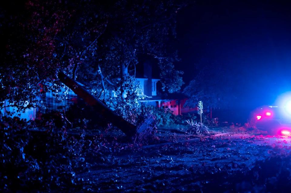 A fallen tree leans on a house near the corner of 95th and Glenwood in Overland Park, Kansas, early in the morning on June 8, 2022, after a suspected tornado struck.