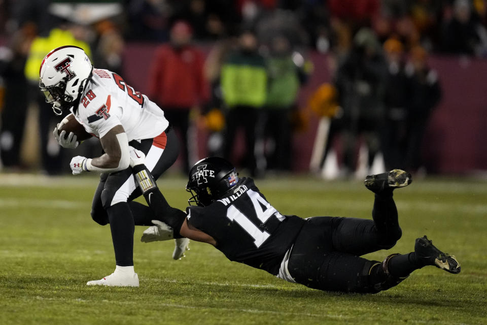 Texas Tech running back Tahj Brooks (28) tries to break a tackle by Iowa State linebacker Carson Willich (14) during the first half of an NCAA college football game, Saturday, Nov. 19, 2022, in Ames, Iowa. (AP Photo/Charlie Neibergall)