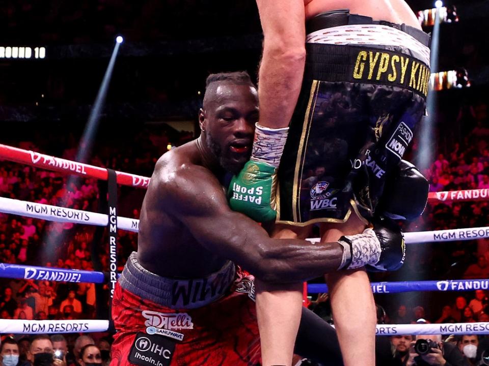 Deontay Wilder holds on after being dropped by Tyson Fury (Getty)