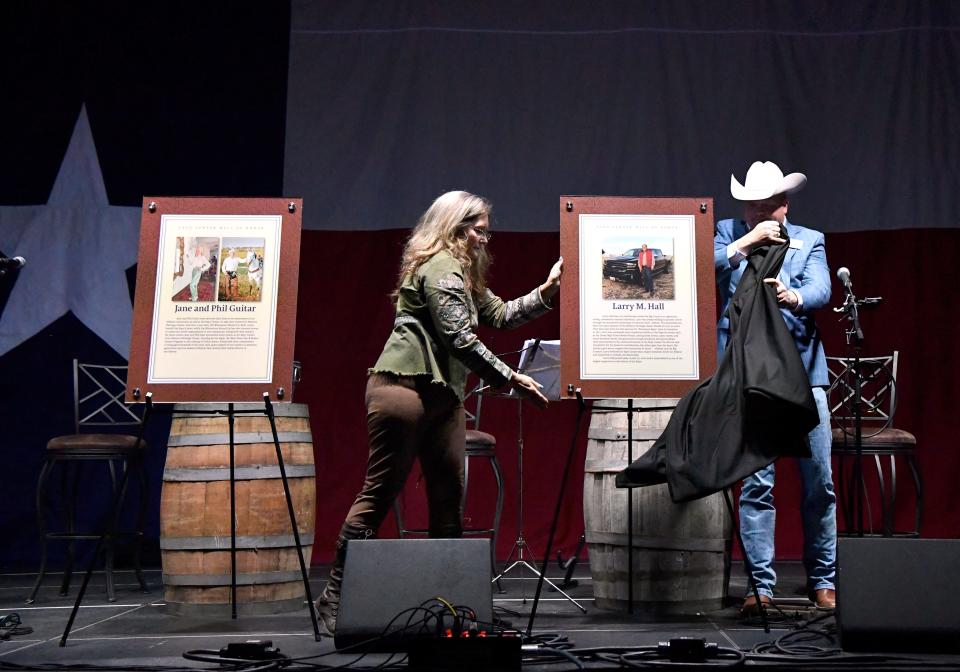 Rochelle Johnson, general manager of the Taylor County Expo Center, and board president Cade Browning unveil the second of two plaques Saturday night at the Taylor County Coliseum. The plaques will go on a new Wall of Honor and recognized Jane and Phil Guitar and the late Larry Hall.