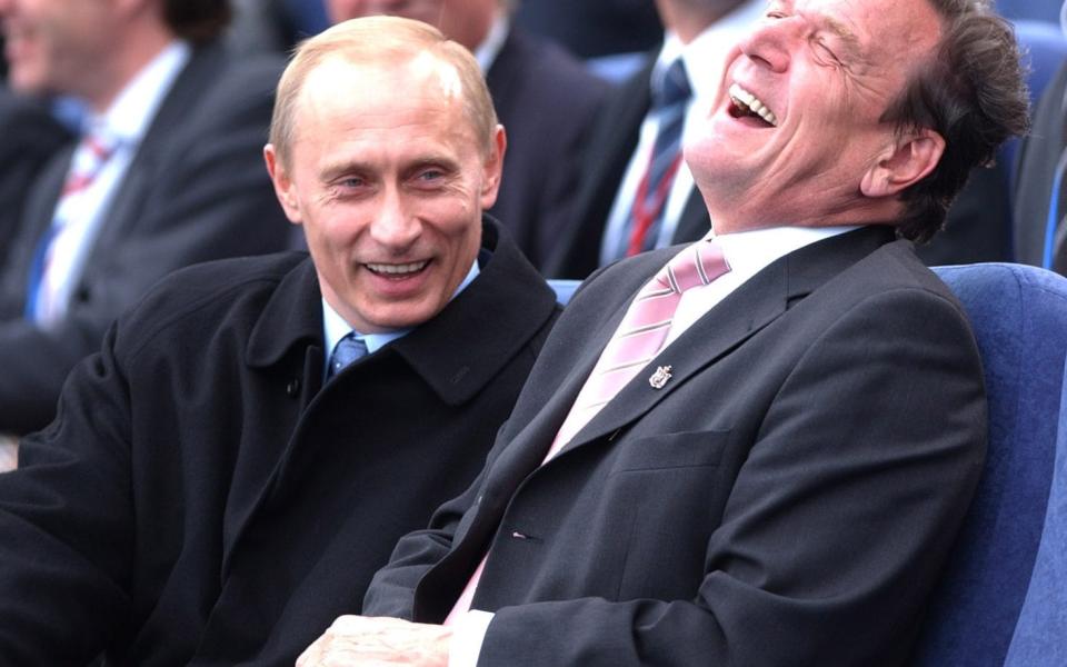 Vladimir Putin and Gerhard Schröder share a joke in St Petersburg in 2003 - PA Photo: Stefan Rousseau