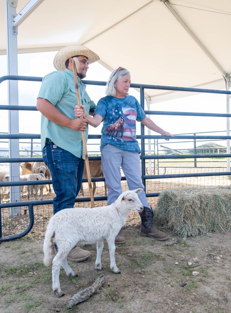 Sheep farmer Ariel Urra, left, and Kim Mickna, of Georgie's Farm, stand near of pen of sheep during a commissioning event for FPL’s Blackwater River Solar Energy Center in Milton on Wednesday, June 7, 2023.  FPL introduced an agrivoltaic pilot program of using sheep to manage vegetation at the site.