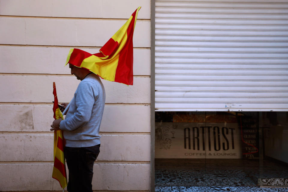 <p>A man prepares a Spanish flag before taking part on a rally against Catalonia’s declaration of independence, in Barcelona, Spain, Sunday, Oct. 29, 2017. (Photo: Gonzalo Arroyo/AP) </p>