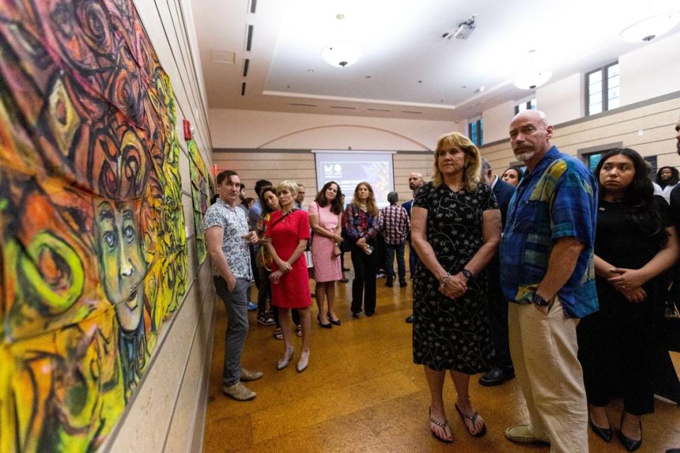 Guests at the Coral Gables Museum gaze at an art piece entitled “The Personification of Heat” during an event hosted by Miami-Dade artist-in-residence Xavier Cortada where he unveiled three new paintings he created.