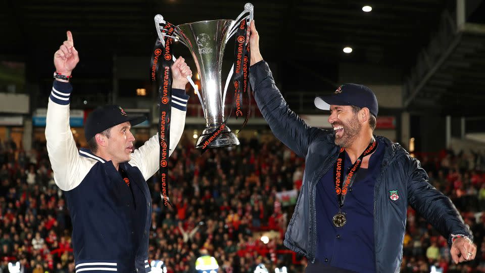 Rob McElhenney and Ryan Reynolds, owners of Wrexham, celebrate with the National League trophy in April. - Jan Kruger/Getty Images