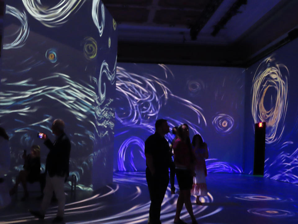 Spectators view an image from the "Beyond Van Gogh" exhibit at the Hard Rock casino in Atlantic City, N.J., on Thursday, July 7, 2022. Some casinos are using fine art galleries or exhibitions to draw new customers who might not otherwise visit a gambling hall. (AP Photo/Wayne Parry)