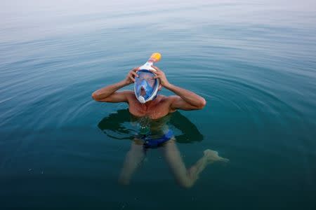 An environmental activist adjusts his mask while taking part in "The Dead Sea Swim Challenge", swimming from the Jordanian to Israeli shore, to draw attention to the ecological threats facing the Dead Sea, in Kibbutz Ein Gedi, Israel November 15, 2016. REUTERS/Nir Elias