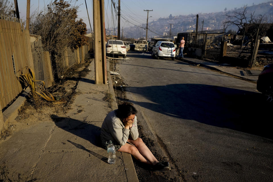 A woman cries losing a friend who died after a forest fire reached Villa Independencia neighborhood in Vina del Mar, Chile, Saturday, Feb. 3, 2024. (AP Photo/ Esteban Felix)