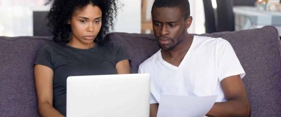 Black worried couple feels confused reading bad news from bank received letter about high health insurance costs.