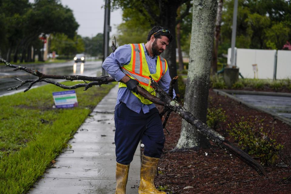 Michael Ciarleglio with the city of Pinellas Park, cleans up a few tree branches while working the morning after Hurricane Elsa moved over the Tampa Bay Area, Wednesday, July 7, 2021 in Pinellas Park, Fla. The Tampa Bay area was spared major damage as Elsa stayed off shore as it passed by. (Martha Asencio-Rhine/Tampa Bay Times via AP)