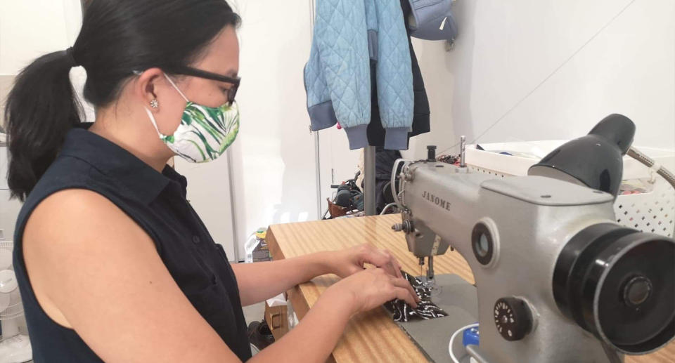 Valerie Diola shown at her sewing machine.