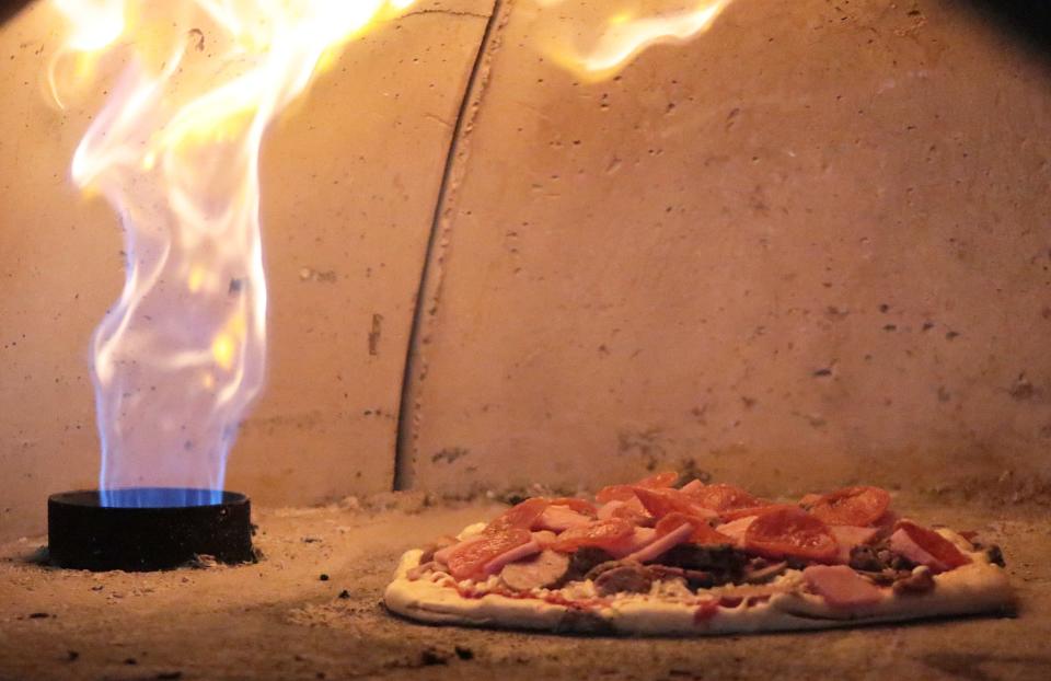 A pizza cooks in the brick oven at Paradise Pizza. “The oven is the key — the taste, the flavor, the sealing everything in,” Scott Chase said. “We are trying to put good flavors together with a quality product, and you can taste the difference.”