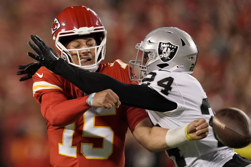 Kansas City Chiefs quarterback Patrick Mahomes (15) throws under pressure from Las Vegas Raiders safety Johnathan Abram (24) during the first half of an NFL football game Monday, Oct. 10, 2022, in Kansas City, Mo. (AP Photo/Charlie Riedel)