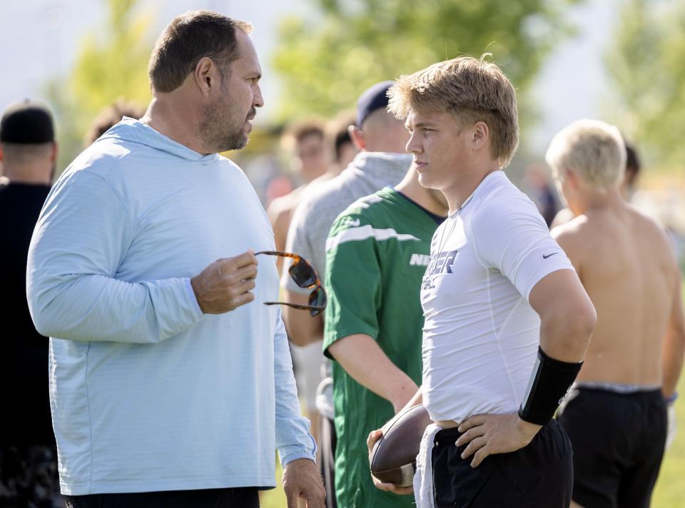 Mike Wilson talks with his son Isaac Wilson during a 7-on-7 passing league game in Layton on Friday, June 9, 2023.