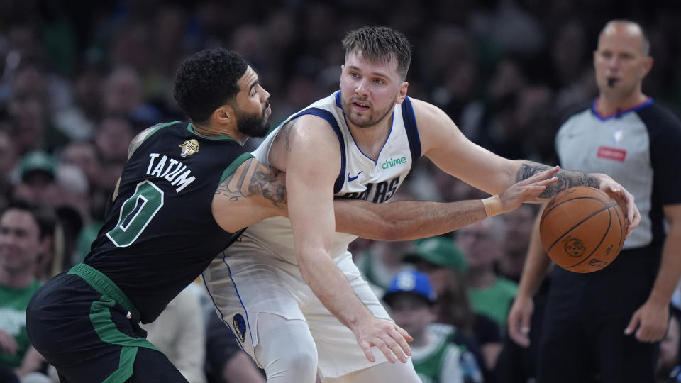 Boston Celtics forward Jayson Tatum (0) pressures Dallas Mavericks guard Luka Doncic, front right, during the first half of Game 2 of the NBA Finals basketball series, Sunday, June 9, 2024, in Boston. (AP Photo/Steven Senne)