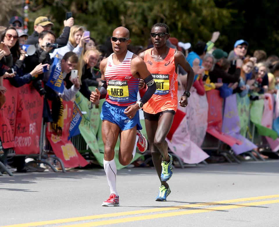 Meb Keflezighi, of the United States, leads Josphat Boit, also from the United States, passed Wellesley College during the 118th Boston Marathon Monday, April 21, 2014 in Wellesley. (AP Photo/Mary Schwalm)