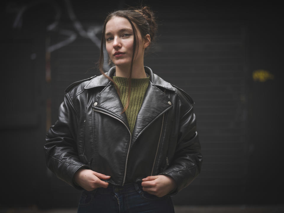 Hasselblad 907X & CFV 100C sample image – street portrait of a young woman wearing a leather jacket with her hair tied up in a ponytail with loose bangs