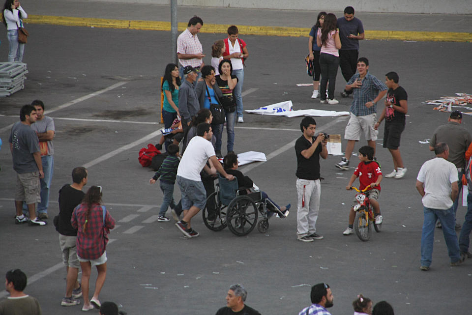 People gather outside a shopping mall after an earthquake was felt in Talca, Chile, Sunday, March 25, 2012. A magnitude-7.2 earthquake has struck just off the coast of central Chile, prompting an emergency evacuation order for people living near the ocean in case it spawns a tsunami. (AP Photo/Fabian Suazo)