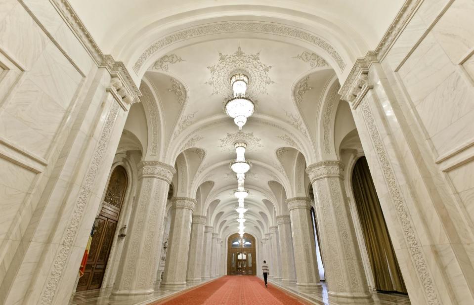 A picture taken on Dec. 12, 2012, shows a man walking inside the Parliament Palace in Bucharest, Romania. Twenty-three years after communism collapsed, the Palace of the Parliament, a gargantuan Stalinist symbol and the most concrete legacy of ex-dictator Nicolae Ceausescu, has emerged as an unlikely pillar of Romania's nascent democracy. And while it remains one of the most controversial projects of Ceausescu's 25-year rule, albeit one that has gradually found a place in the nation's psyche, it's also now a tourist attraction, visited by tens of thousands of Romanians and foreigners every year. (AP Photo/Vadim Ghirda)