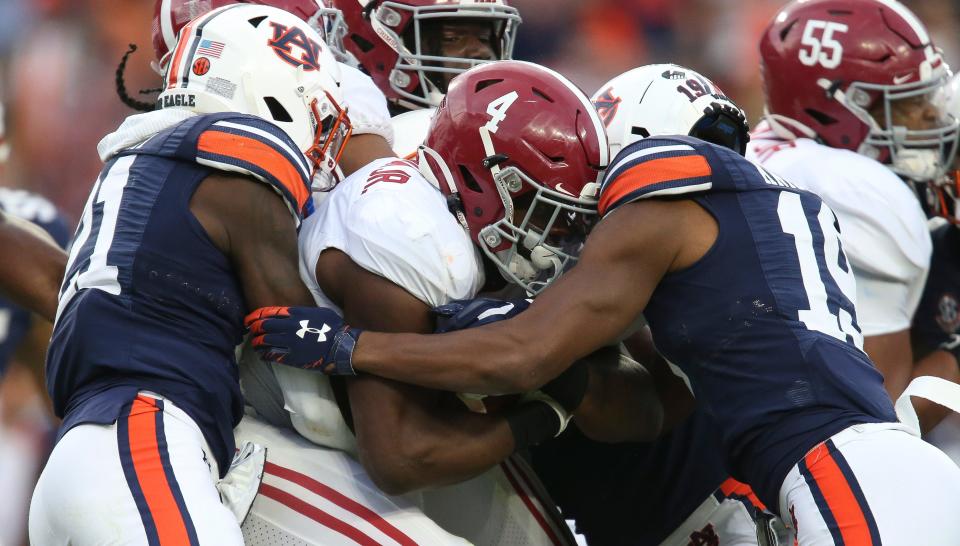 Nov 27, 2021; Auburn, Alabama, USA; Auburn Tigers safety Smoke Monday (21) and Auburn Tigers safety Bydarrius Knighten (19) combine to tackle Alabama running back Brian Robinson Jr. (4)  at Jordan-Hare Stadium. Mandatory Credit: Gary Cosby Jr.-USA TODAY Sports