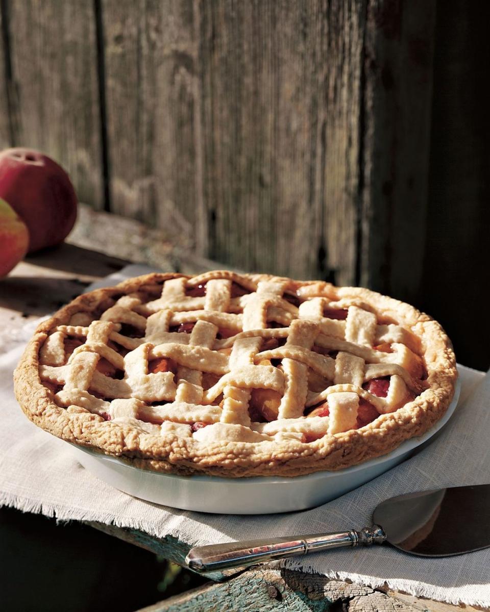 peach almond pie with a lattice crust in a white pie dish