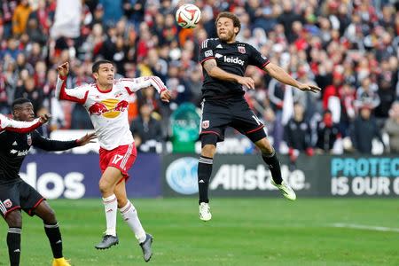 Nov 8, 2014; Washington, DC, USA; D.C. United midfielder Nick DeLeon (14) leaps to head the ball in front of New York Red Bulls midfielder Tim Cahill (17) in the second half of leg 2 of the Eastern Conference semifinals in the 2014 MLS Cup Playoffs at Robert F. Kennedy Memorial. United won the leg 2-1, and the Red Bulls advanced 3-2 on aggregate. Mandatory Credit: Geoff Burke-USA TODAY Sports