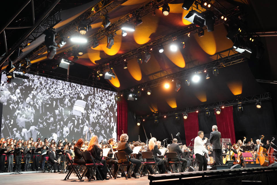 An orchestra performs at Lisbon's Comercio square, Wednesday, April 24, 2024, during a concert to celebrate the fiftieth anniversary of the Carnation Revolution. The April 25, 1974 revolution carried out by the army restored democracy in Portugal after 48 years of a fascist dictatorship. (AP Photo/Armando Franca)