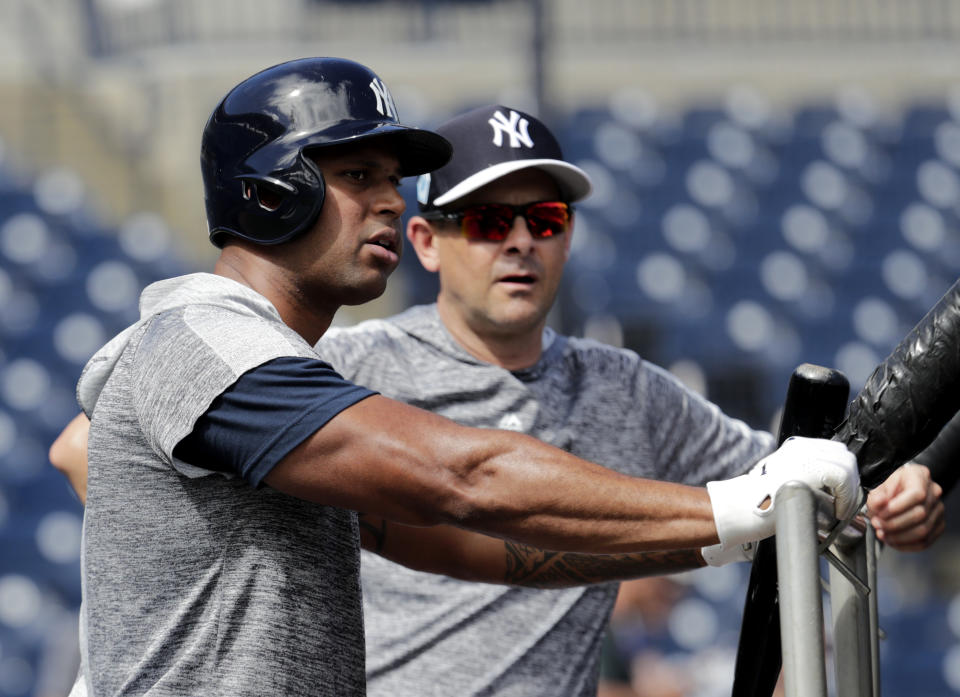 New York Yankees' Aaron Hicks, left, and manager Aaron Boone watch batting practice at the New York Yankees spring training baseball facility, Thursday, Feb. 21, 2019, in Tampa, Fla. (AP Photo/Lynne Sladky)