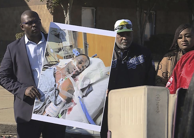 In this photo provided by WREG, Tyre Nichols’ stepfather Rodney Wells, right, holds a photo of Nichols in the hospital after his arrest, during a protest in Memphis, Tenn., Saturday, Jan. 14, 2023. 
