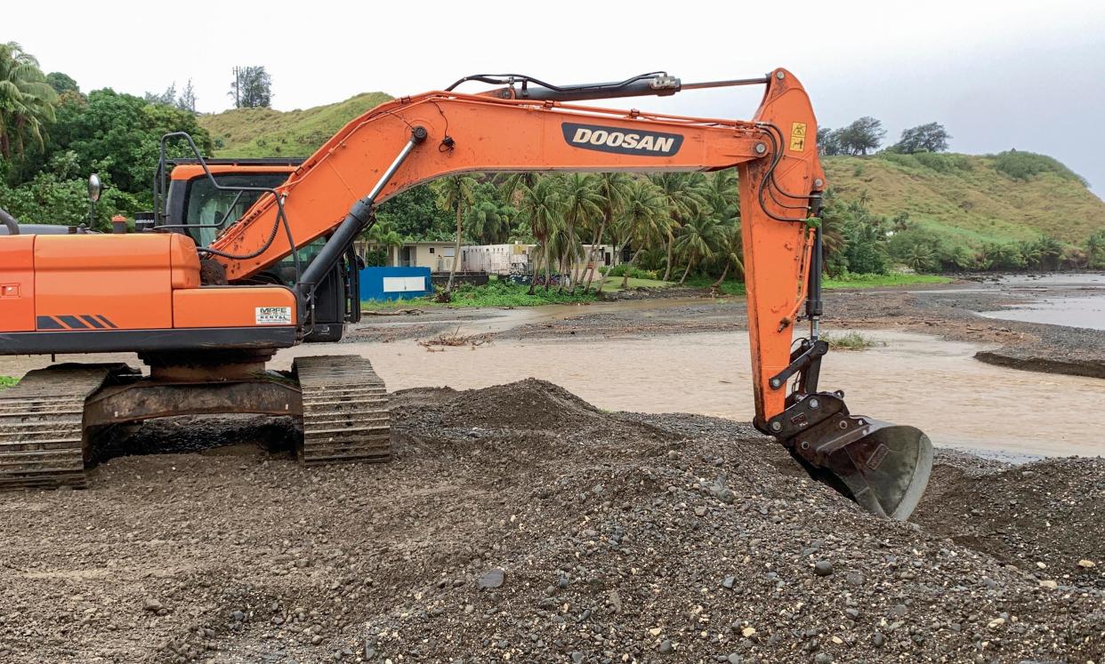 An excavator operator constructs a double berm along the shoreline of the Umatac Bay, near the mouth on the Laelae River (Pacific Daily News PO Box DN Hagåtña, Guam 96932)