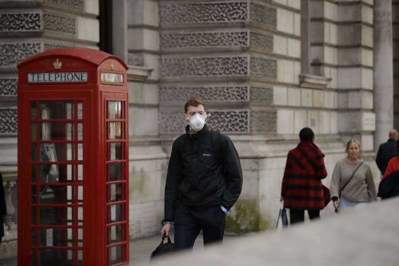 英國的武漢肺炎疫情延燒，倫敦市中心一名男性行人戴著口罩（美聯社）