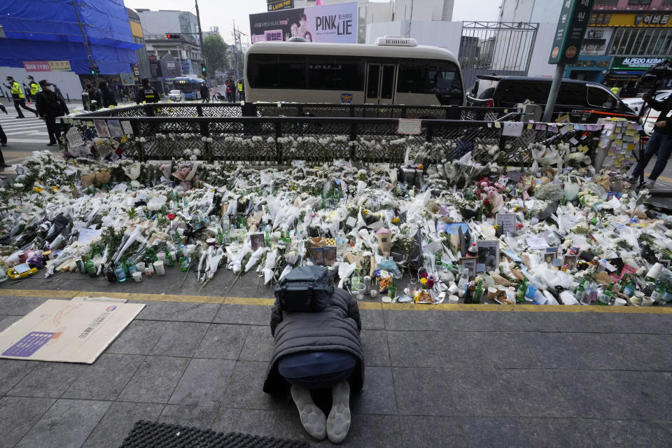 A man bows to pay tribute to victims of a deadly accident following Saturday night's Halloween festivities on a street near the scene in Seoul, South Korea, Tuesday, Nov. 1, 2022. South Korean police investigated on Monday what caused a crowd surge that killed more than 150 people during Halloween festivities in Seoul in the country’s worst disaster in years. (AP Photo/Ahn Young-joon)