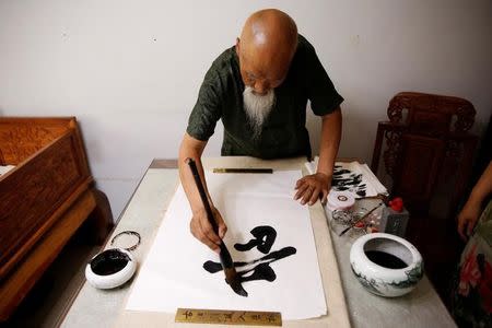 Kung Fu master Li Liangui practices calligraphy at his apartment in Beijing, China, July 2, 2016. REUTERS/Kim Kyung-Hoon