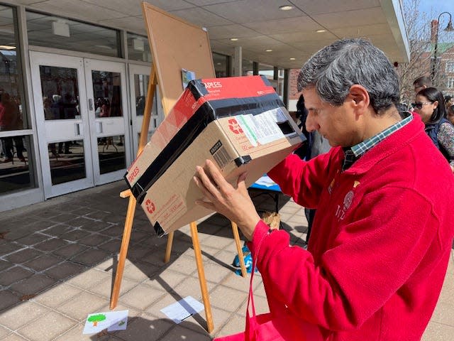 At WPI, physics professor Rudra Kafle examines a homemade viewer in the hours before the solar eclipse on Monday. Hundreds of students were outside on campus in anticipation of the big event.