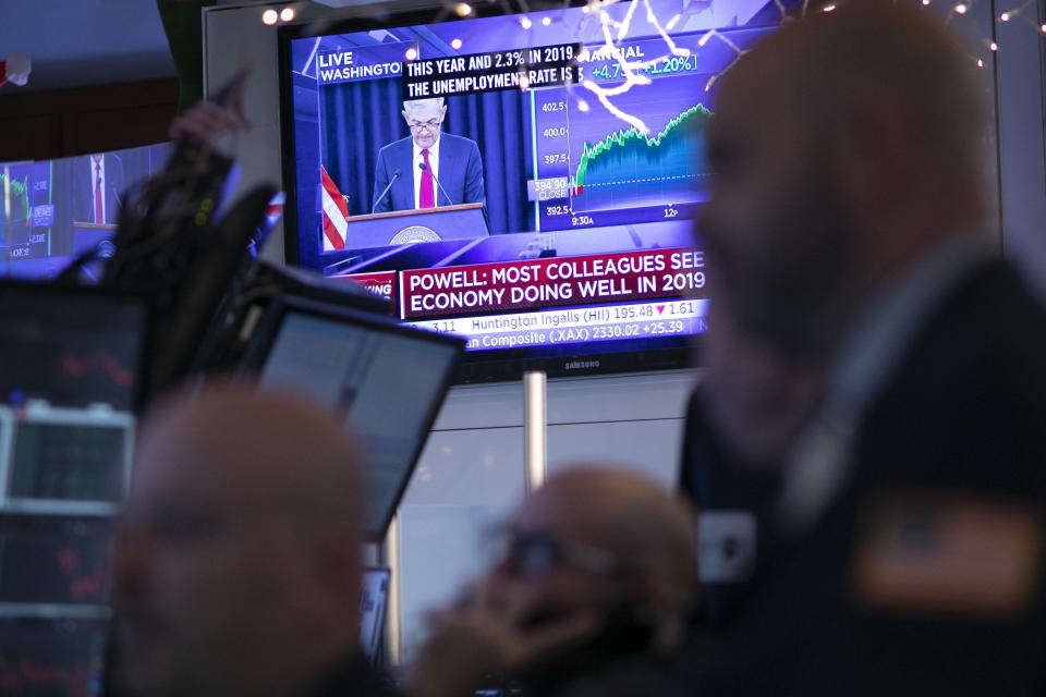 Traders at the New York Stock Exchange listen as Federal Reserve Chair Jerome Powell is seen on a video screen giving a news conference from Washington after the Fed announced a rate increase, Wednesday, Dec. 19, 2018. (AP Photo/Mark Lennihan)