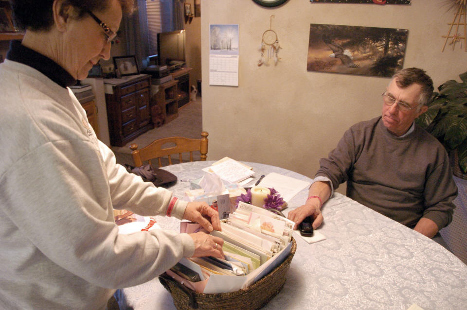 This Feb. 28, 2012 photo shows Ron Whited looking on, as his wife, Sharon, goes through a basket of condolence cards and notes the couple has received since their daughter Sherry Arnold was kidnapped and apparently murdered, in Sidney, Mont. More than 16 million barrels of crude are now being pumped every month from the massive Bakken oil field beneath eastern Montana. But Sidney's new-found prosperity doesn't dull the sting of the recent kidnapping and apparent murder of local teacher, Arnold, who authorities allege was snatched from a Sidney street. .(AP Photo/Matthew Brown)