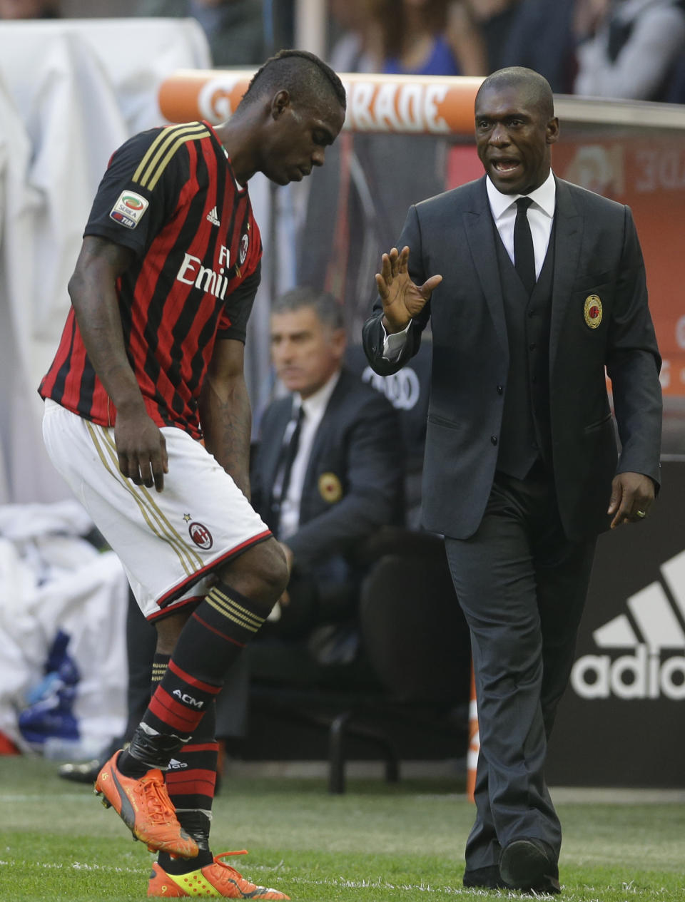 AC Milan coach Clarence Seedorf, of the Netherlands, talks to AC Milan forward Mario Balotelli during a Serie A soccer match between AC Milan and Parma, at the San Siro stadium in Milan, Italy, Sunday, March 16, 2014. (AP Photo/Luca Bruno)