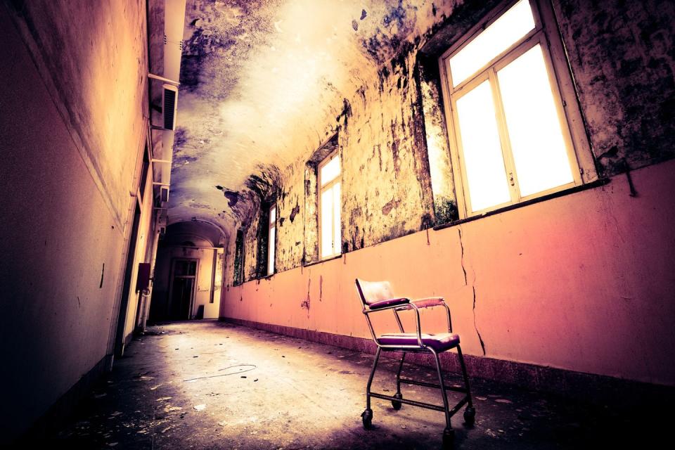 <p>An empty chair is all that remains in this abandoned hospital corridor.</p>