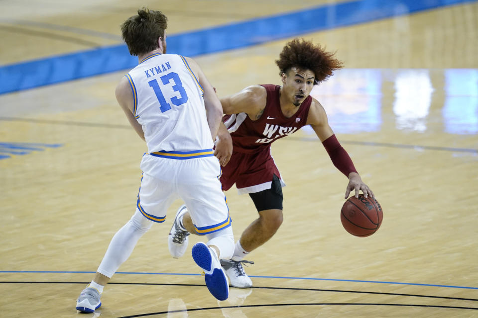 UCLA guard Jake Kyman (13) defends against Washington State guard Isaac Bonton, right, during the first half of an NCAA college basketball game Thursday, Jan. 14, 2021, in Los Angeles. (AP Photo/Ashley Landis)