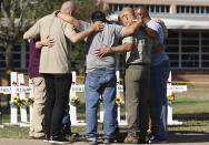 Men form a prayer circle at a memorial site for the victims of the Robb Elementary School shooting, Thursday, May 26, 2022, in Uvalde, Texas. (Kin Man Hui/The San Antonio Express-News via AP)