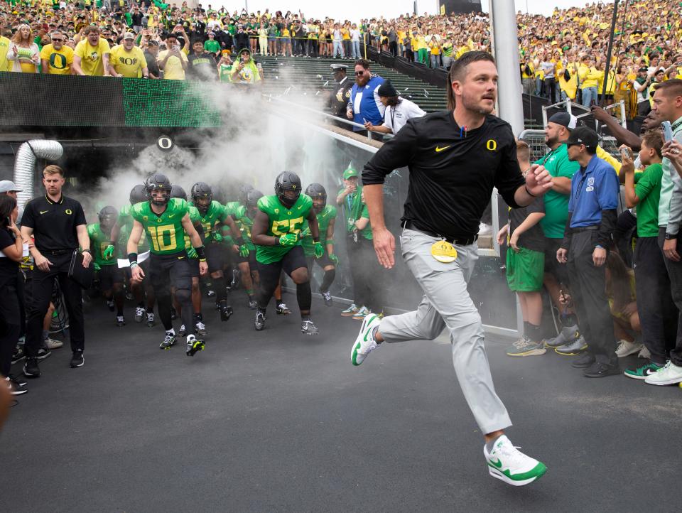 Oregon head coach Dan Lannning leads his team on the field before the game against Colorado in Eugene on Sept. 23.