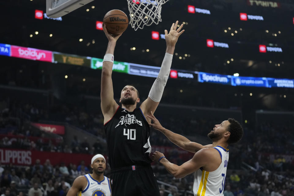 Los Angeles Clippers center Ivica Zubac (40) shots against Golden State Warriors guard Stephen Curry (30) during the first half of an NBA basketball game in Los Angeles, Saturday, Dec. 2, 2023. (AP Photo/Ashley Landis)