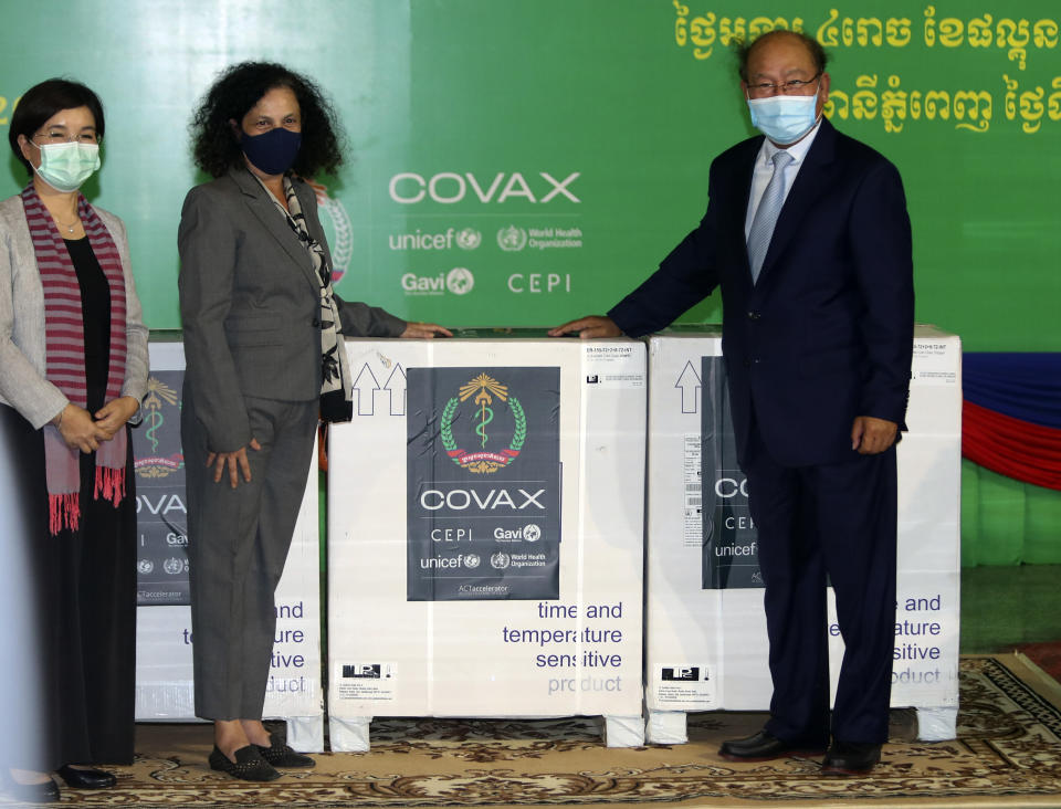 Cambodian Health Minister Mam Bun Heng, right, receives boxes of COVID-19 vaccines from World Health Organization (WHO) representative to Cambodia Dr. Li Ailan, left, Unicef country representative in Cambodia, EU Ambassador Carmen Moreno, center, during a handover ceremony of COVID-19 vaccines from the COVAX Facility at Phnom Penh International Airport, in Phnom Penh, Cambodia, Tuesday, March 2, 2021. More than 300,000 doses of AstraZeneca COVID-19 vaccines from Serum Institute of India on Tuesday arrived Phnom Penh, as part of global COVAX initiative. (AP Photo/Heng Sinith)