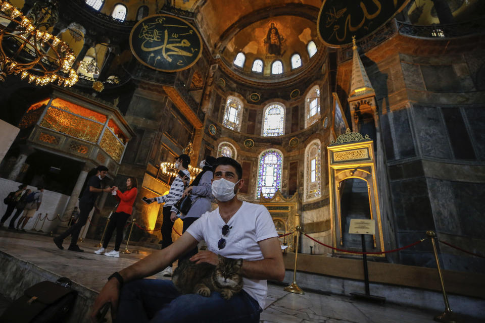 People visit the Byzantine-era Hagia Sophia, one of Istanbul's main tourist attractions in the historic Sultanahmet district of Istanbul, Thursday, June 25, 2020. The 6th-century building is now at the center of a heated debate between conservative groups who want it to be reconverted into a mosque and those who believe the World Heritage site should remain a museum. (AP Photo/Emrah Gurel)