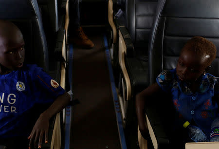 Machiey Mario, 8 (L), and Nyawan Mario, 4, fly on a United Nations plane to Juba where they will be reunited with their mother, near Bentiu, South Sudan, February 13, 2017. REUTERS/Siegfried Modola