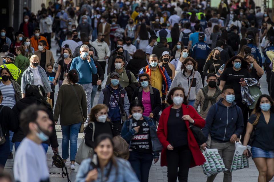 People wearing face masks to protect against the spread of coronavirus walk in downtown Madrid, Spain, Wednesday, March 31, 2021. Spain is bracing for another potential sharp increase in coronavirus cases. And with the vaccine rollout being outpaced by the new more contagious variant of the virus, authorities are asking for citizens to intensify their precautions to "buy time" for the shots to arrive. (AP Photo/Manu Fernandez)