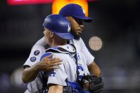 Los Angeles Dodgers relief pitcher Kenley Jansen, rear, hugs catcher Will Smith after the team's 3-0 win in a baseball game against the Arizona Diamondbacks on Friday, June 18, 2021, in Phoenix. (AP Photo/Ross D. Franklin)