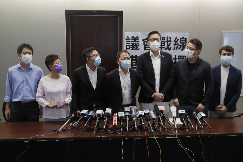 Hong Kong Democratic Party lawmakers from left; Ted Hui Chi-fung, Helena Wong Pik-wan, Lam Cheuk-ting, Wu Chi-wai, James To, Andrew Wan Siu-kin and Roy Kwong Chun-yu attend a press conference in Hong Kong, Thursday, Aug. 20, 2020. Lawmakers from Hong Kong's largest pro-democracy party, the Democratic Party, said Thursday they planned to hold a poll and debate to determine whether they will continue serving another year in the city's legislature, following a postponement of elections due to the coronavirus outbreak. The placard reads "Legislature war, the decision of Hong Kong people". (AP Photo/Kin Cheung)